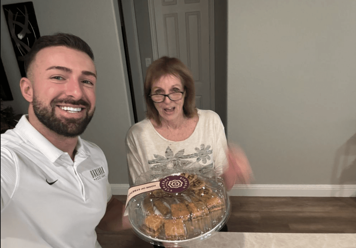 John bringing a tray of fresh baklava to a Baklava Roofing customer